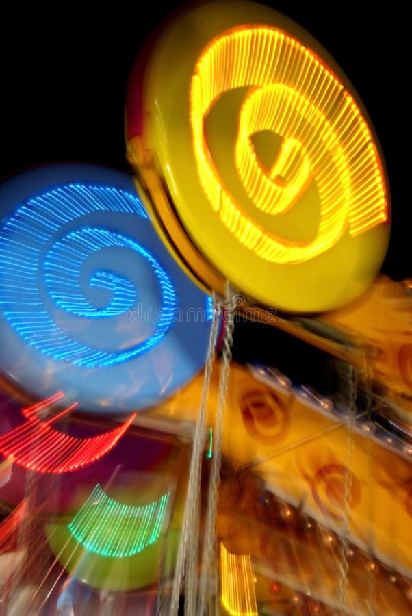 A colorful, brightly-lit ride at a carnival or amusement park at night. A colorful, brightly-lit ride at a carnival or amusement park at night