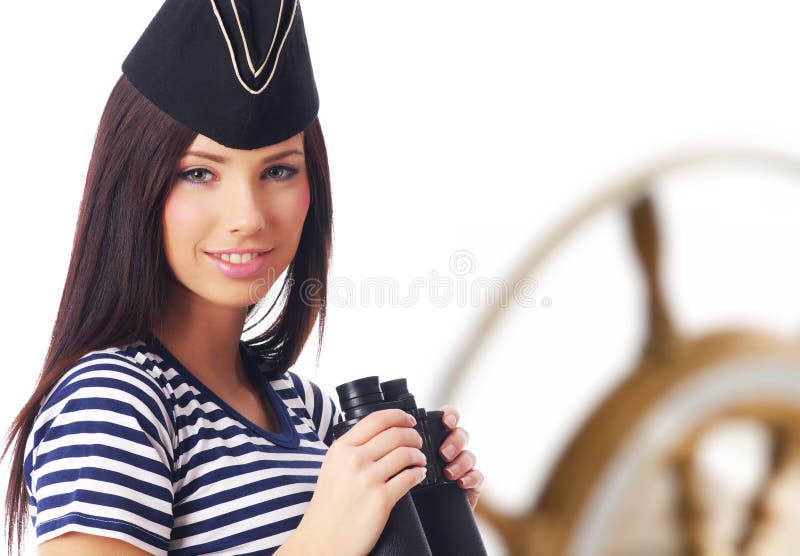 Young captain girl standing on the yacht is looking through. Young captain girl standing on the yacht is looking through