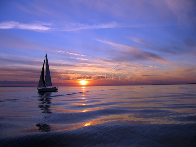 Scenic view of yacht sailing at sunset with cloudscape background. Scenic view of yacht sailing at sunset with cloudscape background.