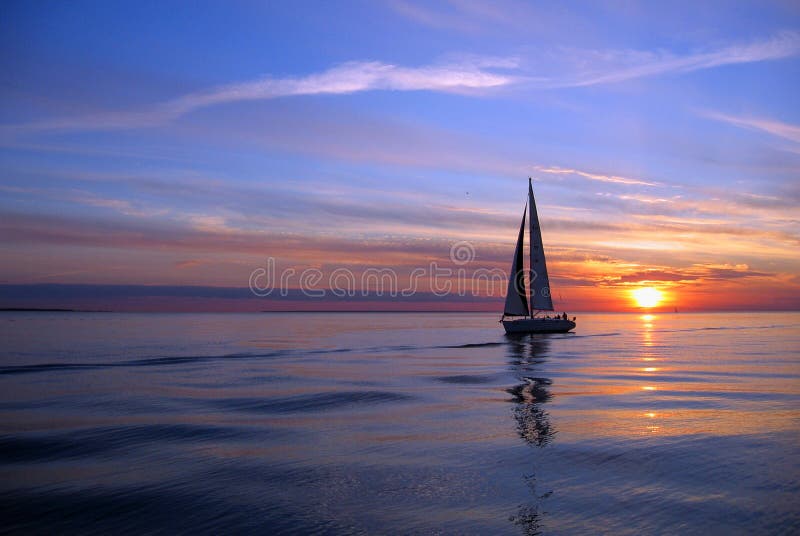 Scenic view of silhouetted yacht at sea with sunset and cloudscape background. Scenic view of silhouetted yacht at sea with sunset and cloudscape background.