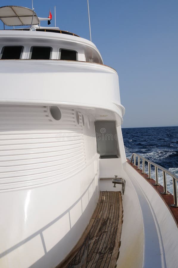 Deck of big wooden marine yacht with portholes and deck cabin in the sea. Deck of big wooden marine yacht with portholes and deck cabin in the sea