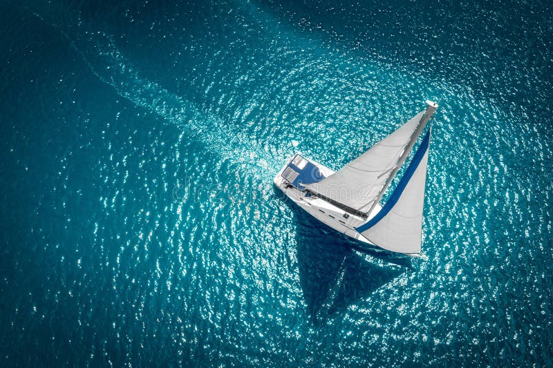 Regatta sailing ship yachts with white sails at opened sea. Aerial view of sailboat in windy condition. Regatta sailing ship yachts with white sails at opened sea. Aerial view of sailboat in windy condition.