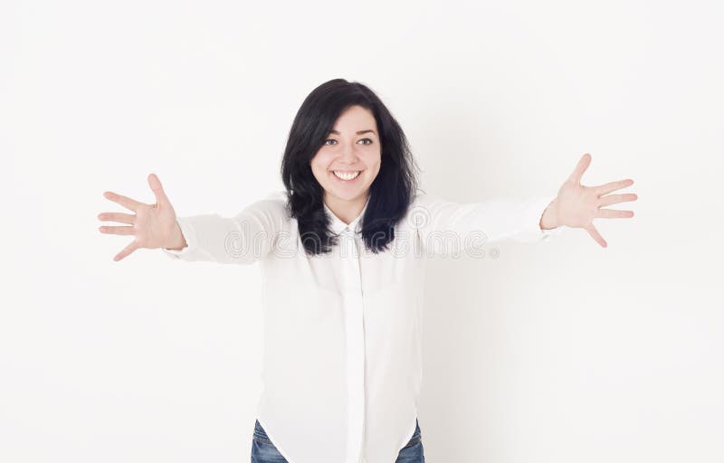 一件白色女衬衫的少妇以拥抱某人的被伸出的手,她是受欢迎微笑 库存图片 一件白色女衬衫的少妇以拥抱某人的被伸出的手,她是受欢迎微笑 库存图片