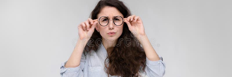 一个女孩的纵向玻璃的 灰色背景的美丽的女孩 轻的女衬衫和黑暗的一个女孩 免版税库存照片 一个女孩的纵向玻璃的 灰色背景的美丽的女孩 轻的女衬衫和黑暗的一个女孩 免版税库存照片