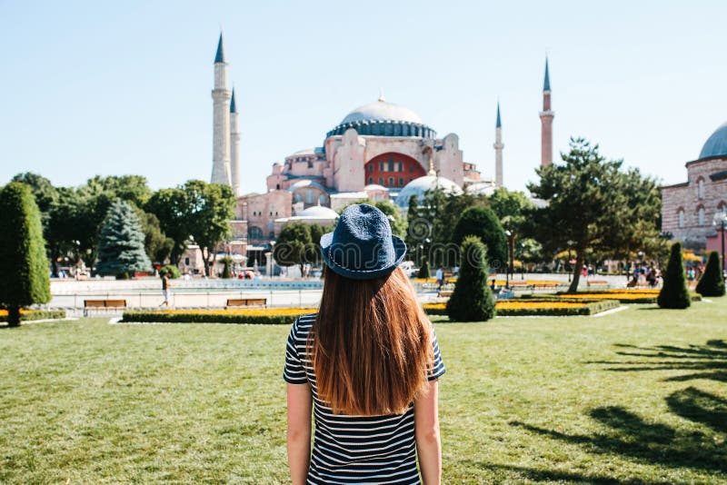 一个帽子的一个女孩旅客从后面在著名Aya索非亚清真寺旁边的Sultanahmet广场在伊斯坦布尔 免版税库存照片 一个帽子的一个女孩旅客从后面在著名Aya索非亚清真寺旁边的Sultanahmet广场在伊斯坦布尔 免版税库存照片