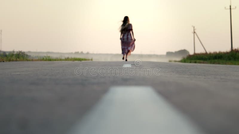 一个穿着长裙的漂亮小女孩赤脚穿着马路，她很快乐，也很自在 慢动作，模糊