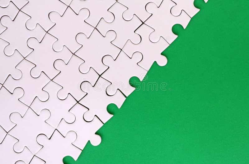一个被折叠的白色七巧板的片段在绿色塑料表面的背景的 与拷贝空间的纹理照片文本的 库存图片 一个被折叠的白色七巧板的片段在绿色塑料表面的背景的 与拷贝空间的纹理照片文本的 库存图片