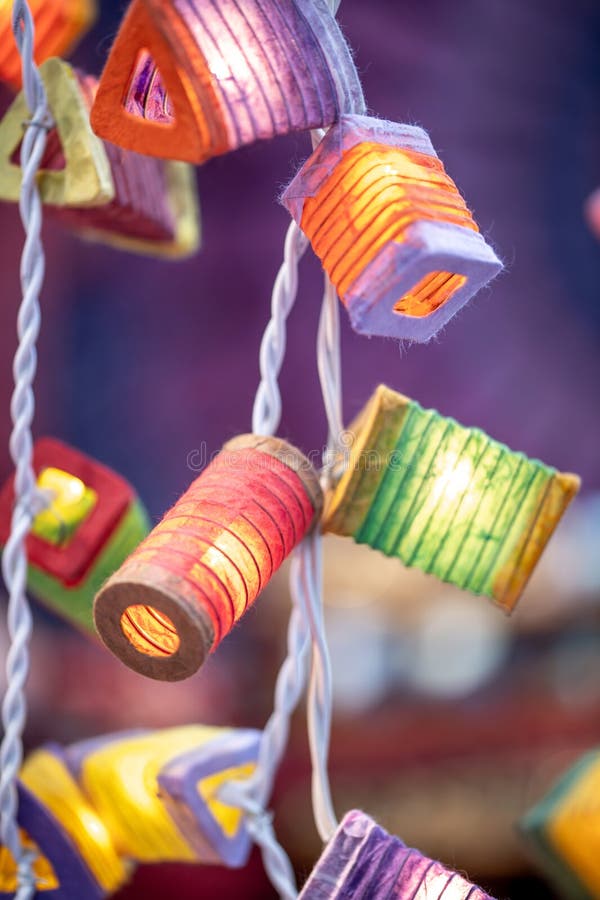 A string of lights with small colorful paper lanterns shining in different colors. A string of lights with small colorful paper lanterns shining in different colors