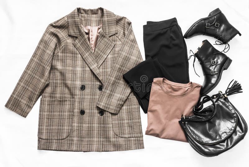 Set of women`s fashion clothing - plaid jacket, black trousers, t-shirt, leather shoes and bag on a light background, top view. Flat lay. Set of women`s fashion clothing - plaid jacket, black trousers, t-shirt, leather shoes and bag on a light background, top view. Flat lay.