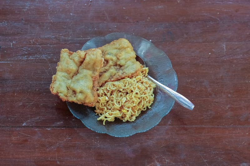 photo of fried noodles with 2 fried tempeh that served for breakfast. photo of fried noodles with 2 fried tempeh that served for breakfast