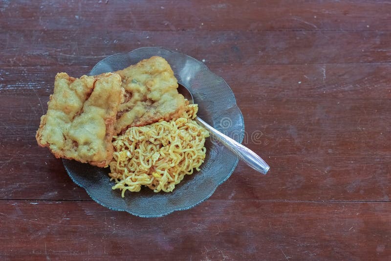 photo of fried noodles with 2 fried tempeh that served for breakfast. photo of fried noodles with 2 fried tempeh that served for breakfast