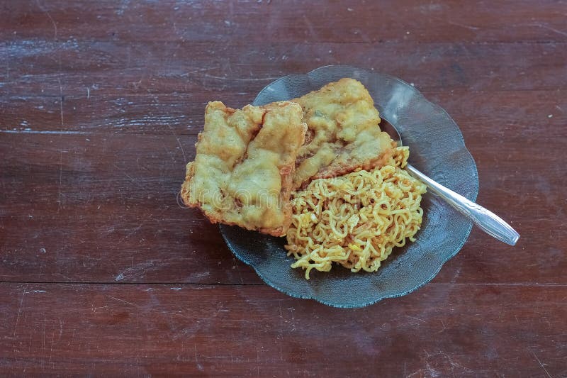 photo of fried noodles with 2 fried tempeh that served for breakfast. photo of fried noodles with 2 fried tempeh that served for breakfast