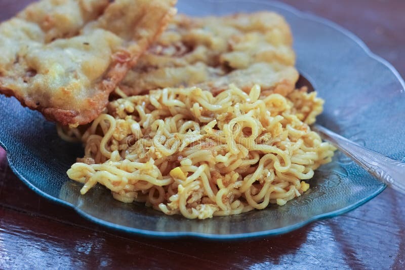 photo of fried noodles with 2 fried tempeh that served for breakfast. photo of fried noodles with 2 fried tempeh that served for breakfast