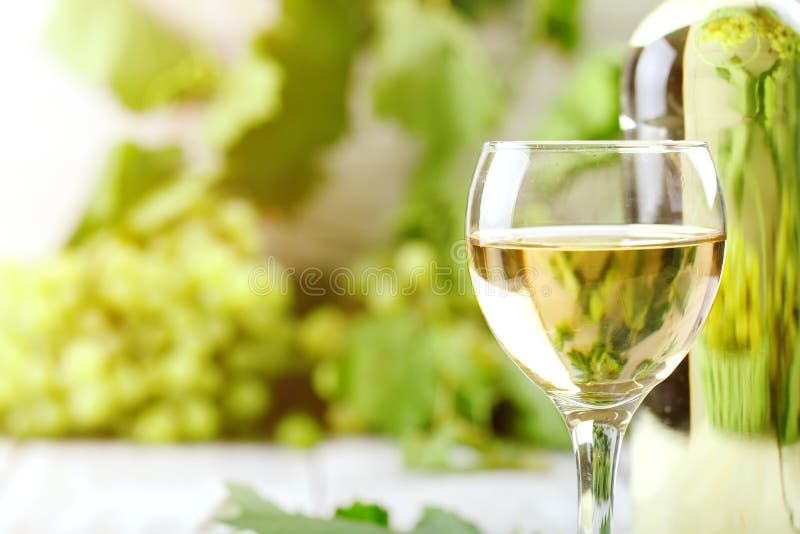 一杯白葡萄酒、新鲜的葡萄和一个瓶在一张木桌上的白葡萄酒 免版税库存照片 一杯白葡萄酒、新鲜的葡萄和一个瓶在一张木桌上的白葡萄酒 免版税库存照片