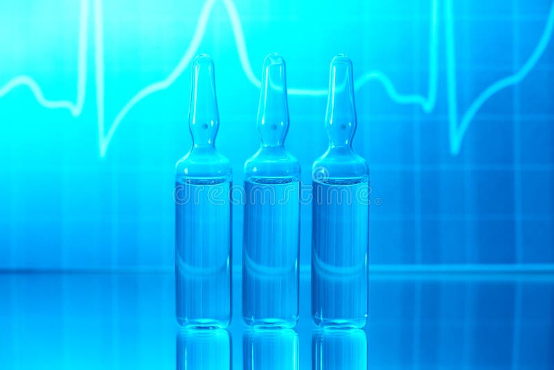 Ampules filled with medicine and EKG in background. Ampules filled with medicine and EKG in background