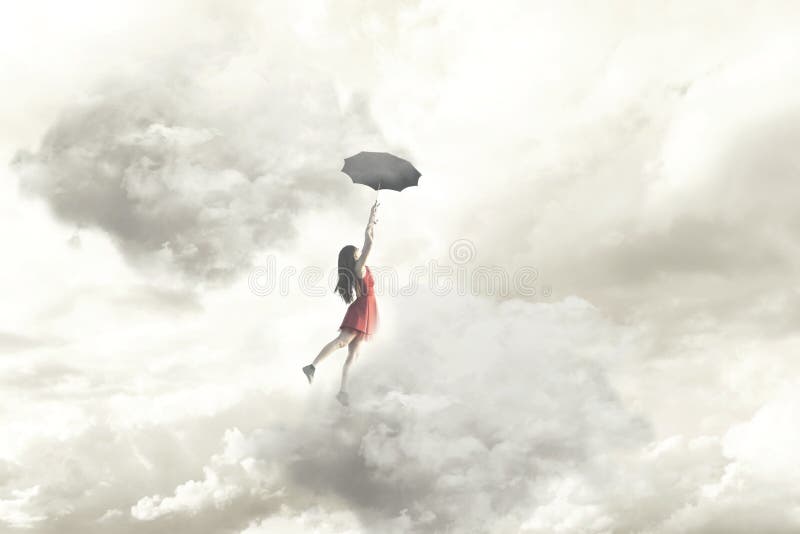 一次端庄的妇女飞行的超现实的片刻在垂悬在她的伞的云彩中间的