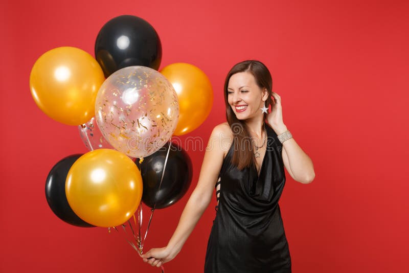 一点黑礼服的庆祝俏丽的年轻女人拿着气球被隔绝在红色背景 St华伦泰` s 免版税库存图片 一点黑礼服的庆祝俏丽的年轻女人拿着气球被隔绝在红色背景 St华伦泰` s 免版税库存图片