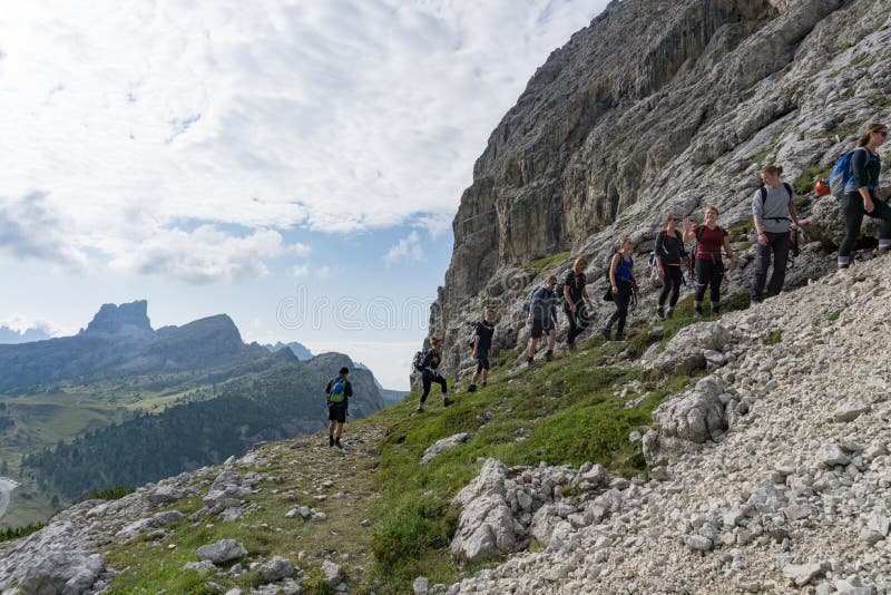一群登山者沿着山边登山到一条难以攀登的路线
