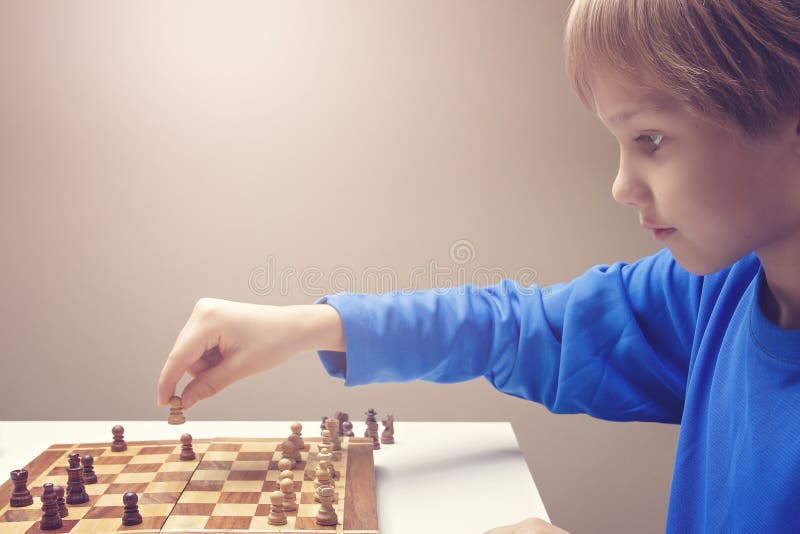下棋的一个小白种人男孩的画象 免版税库存图片