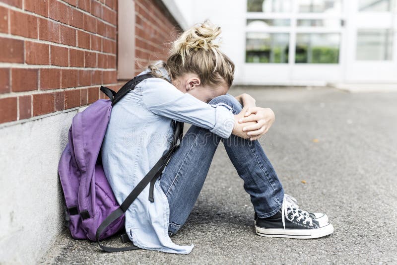 不快乐的前青少年的女孩在学校 库存图片