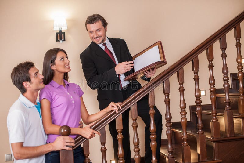 与年轻夫妇的房地产经纪商在梯子