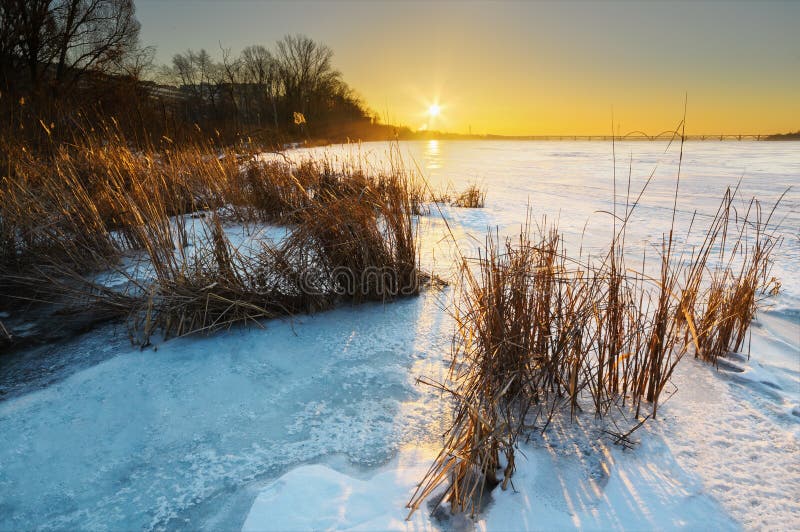 与冻湖和日落天空的美好的冬天风景