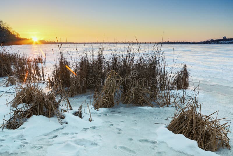 与冻湖和日落天空的美好的冬天风景
