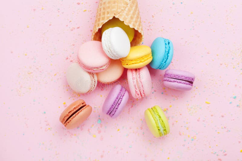 与macaron的甜奶蛋烘饼在桃红色淡色背景顶视图的锥体或蛋白杏仁饼干 平的位置构成 库存照片 与macaron的甜奶蛋烘饼在桃红色淡色背景顶视图的锥体或蛋白杏仁饼干 平的位置构成 库存照片