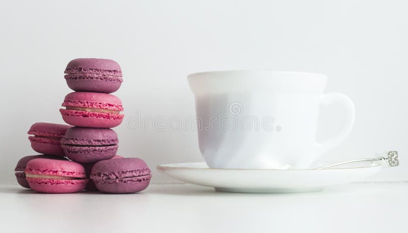 与五颜六色的macarons和茶杯的下午茶桌 免版税库存照片