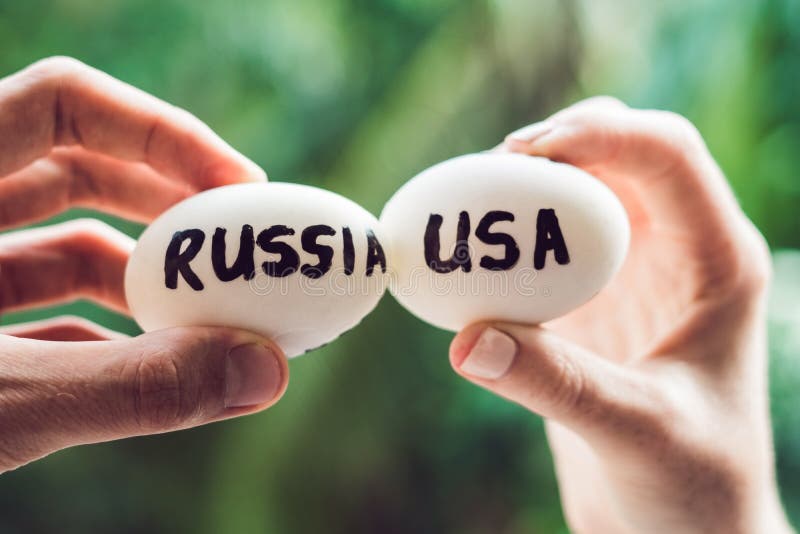 Eggs with the inscriptions of Russia and the United States, fight, who are broken. conflict between USA vs Russia, governments conflict concept. Eggs with the inscriptions of Russia and the United States, fight, who are broken. conflict between USA vs Russia, governments conflict concept.