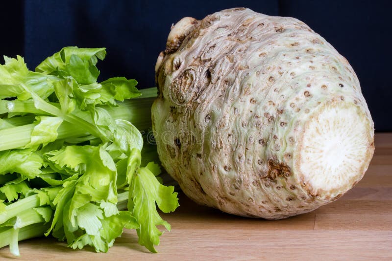 Fresh celery root with it's leafs on wooden table. Fresh celery root with it's leafs on wooden table