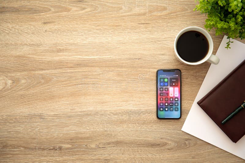 Alushta, Russia - August 26, 2018: iPhone X with home screen Control Center and background wooden desk. iPhone 10 was created and developed by the Apple inc. Alushta, Russia - August 26, 2018: iPhone X with home screen Control Center and background wooden desk. iPhone 10 was created and developed by the Apple inc.