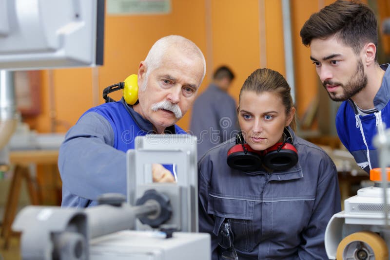 年轻女子在木工车间与老师一起工作 免版税图库摄影