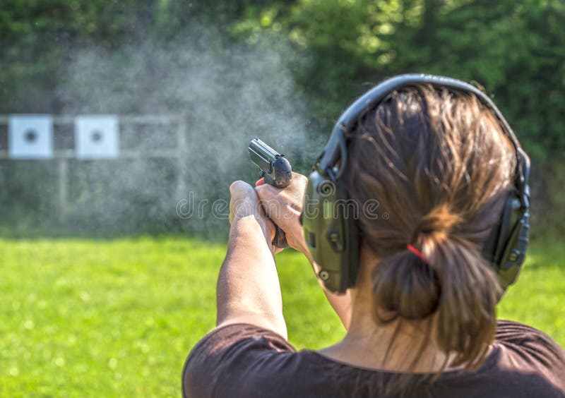 Girl shooting with a gun on a training course. Girl shooting with a gun on a training course.