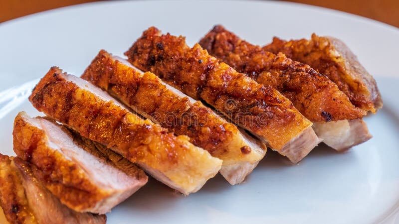 与酥脆皮肤的枯萎的鸭胸脯在一块白色陶瓷板材 库存照片 与酥脆皮肤的枯萎的鸭胸脯在一块白色陶瓷板材 库存照片