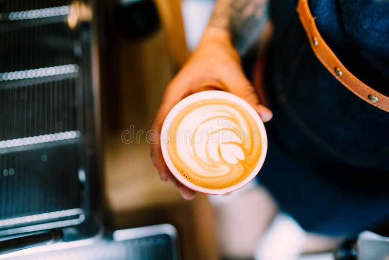 专业barista在做新鲜的热奶咖啡和煮咖啡的咖啡馆 免版税库存图片 专业barista在做新鲜的热奶咖啡和煮咖啡的咖啡馆 免版税库存图片