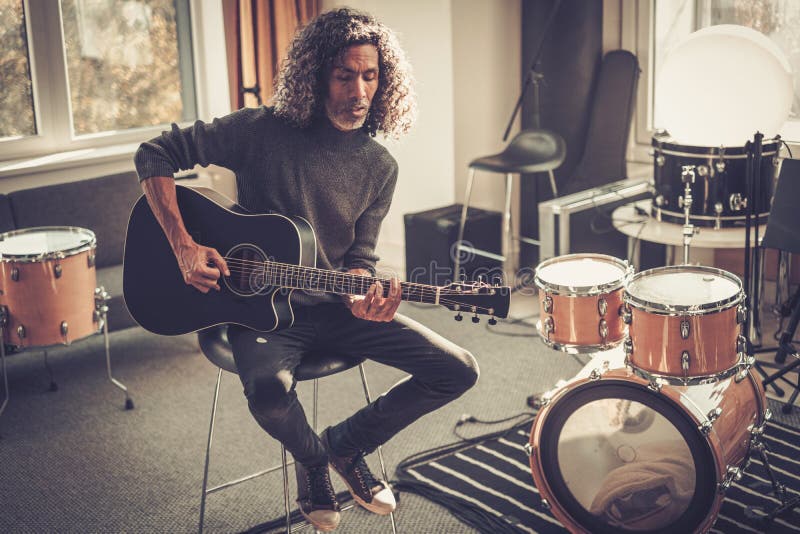 专攻男吉他手在演播室弹吉他. 图库摄影