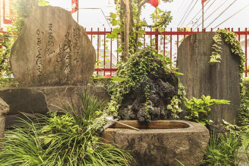 Poem of the 18th century Japanese poet Ota Nanpo on a large stone stele about foxes in the small Shinto Santuary dedicated to the Uga-no-Mitama divinity meaning `the spirit of the rice in storehouses` which is associated with food and agriculture and which is often represented in the form of the fox Inari the divinity of rice. Located in the city of Oji in the district of Kita north of Tokyo, this. Poem of the 18th century Japanese poet Ota Nanpo on a large stone stele about foxes in the small Shinto Santuary dedicated to the Uga-no-Mitama divinity meaning `the spirit of the rice in storehouses` which is associated with food and agriculture and which is often represented in the form of the fox Inari the divinity of rice. Located in the city of Oji in the district of Kita north of Tokyo, this