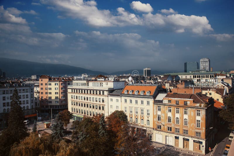 Aerial view of East European City. Many buildings with a mountain background. Urban sprawl. Rila hotel view. Bulgaria, Sofia - September 1, 2018. Aerial view of East European City. Many buildings with a mountain background. Urban sprawl. Rila hotel view. Bulgaria, Sofia - September 1, 2018.