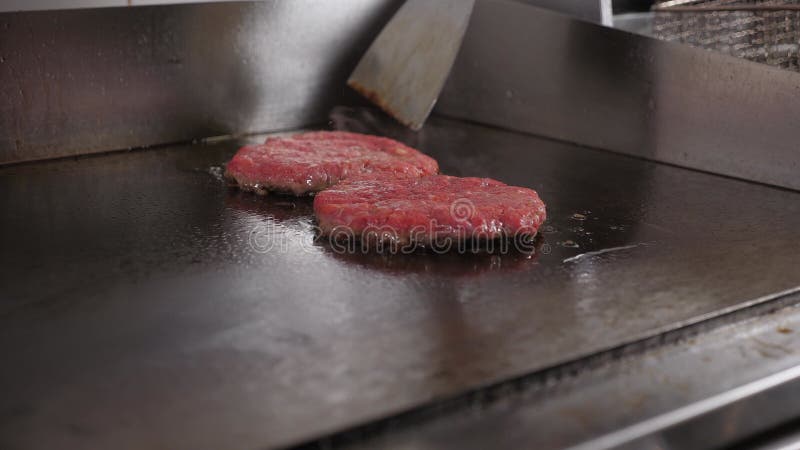 两个在热工业烤炉里炸的肉汉堡包的特写. 股票视频