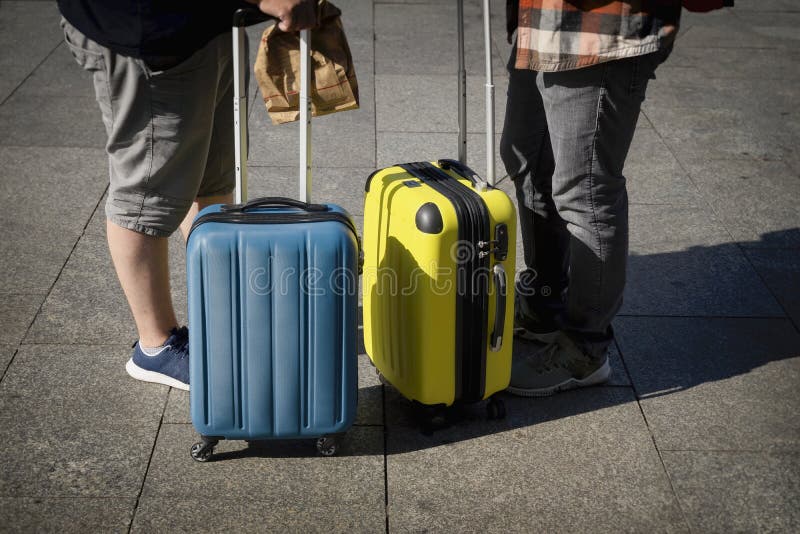 两个年轻男人面目全非,旅客们站在手提箱附近,夏日阳光日,旅游和旅游概念 免版税库存照片 两个年轻男人面目全非,旅客们站在手提箱附近,夏日阳光日,旅游和旅游概念 免版税库存照片