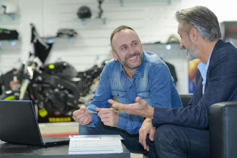 两个男人在买摩托车 免版税库存照片