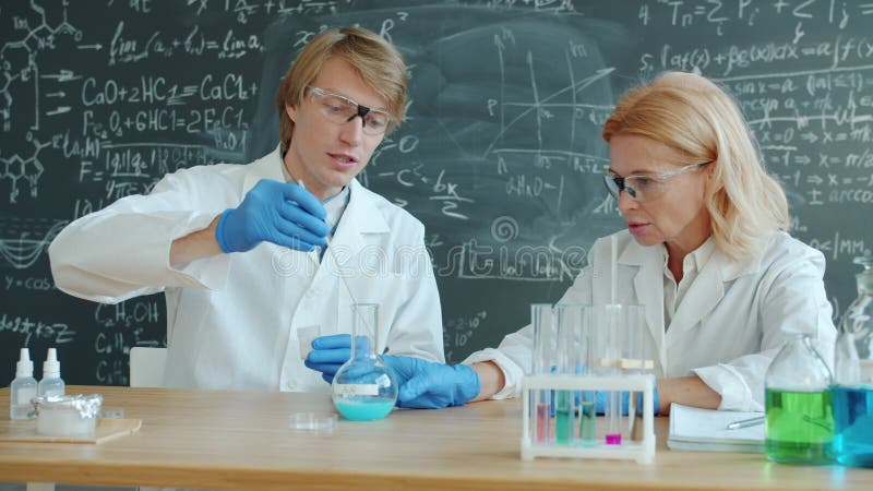 严肃男女在课堂上做化学实验的慢动作