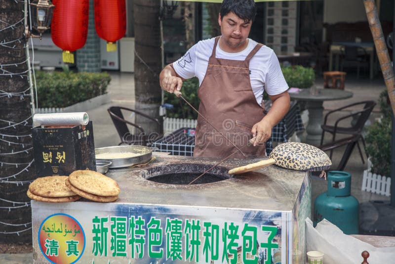 中国、海南岛,大东海湾–2018年12月1日:大东海湾,用泥炉烤面包饼 从传统 库存图片 中国、海南岛,大东海湾–2018年12月1日:大东海湾,用泥炉烤面包饼 从传统 库存图片