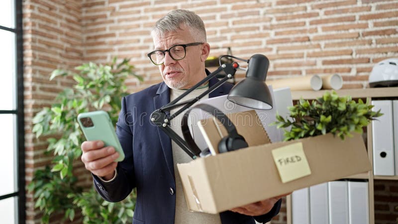 Middle age grey-haired man business worker dismissed using smartphone at office. Middle age grey-haired man business worker dismissed using smartphone at office