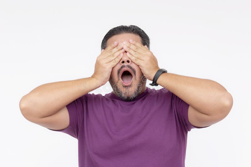 A middle aged guy covering his eyes with both hands after being blinded by a light or afraid by a disturbing sight. Isolated on a white background. A middle aged guy covering his eyes with both hands after being blinded by a light or afraid by a disturbing sight. Isolated on a white background.