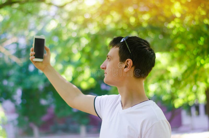 为照相的美丽的年轻欧洲人和在城市做selfie停放户外 生活方式,概念步行 免版税库存照片 为照相的美丽的年轻欧洲人和在城市做selfie停放户外 生活方式,概念步行 免版税库存照片