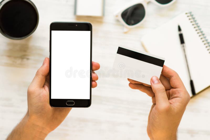 举行手信用卡和使用智能手机 黑智能手机的嘲笑和一张信用卡在手上 库存图片 举行手信用卡和使用智能手机 黑智能手机的嘲笑和一张信用卡在手上 库存图片