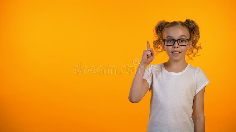 举隔绝的小天才女孩手指在橙色背景，有想法