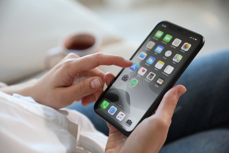 MYKOLAIV, UKRAINE - MARCH 16, 2020: Woman holding iPhone 11 with home screen indoors, closeup. MYKOLAIV, UKRAINE - MARCH 16, 2020: Woman holding iPhone 11 with home screen indoors, closeup